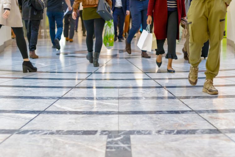 Concept, selective focus, a modern floor with legs of a crowd walking